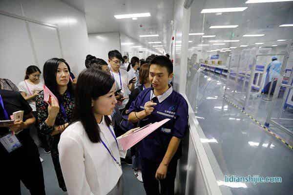 华亿比科工作人员向采访团记者介绍锂电池生产线